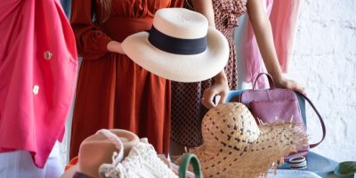 Žena drží v ruce slaměný klobouk