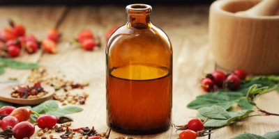 Šípkový sirup v láhvi, okolo plody šípku