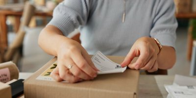 Žena lepí etiketu na krabici