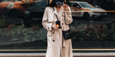 Žena v dlouhém béžovém trenčkotu na ulici