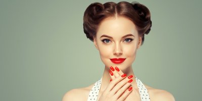 Žena s pin up účesem, červenou rtěnkou a červenými nehty