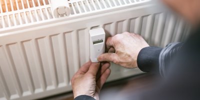 Muž kontroluje čidlo na radiátoru
