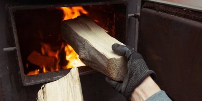 Muž přikládá do kamen