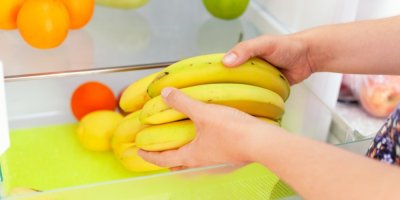 Ruce dávající banány do lednice