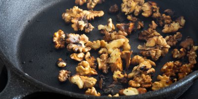 Opražené vlašské ořechy na pánvi