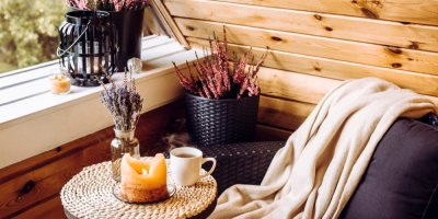 Deka, vřes, světýlka, křeslo a zapálené svíčky na podzimní terase