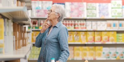 Starší žena se dívá do regálu v obchodě