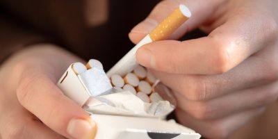 Muž vytahuje cigaretu z krabičky