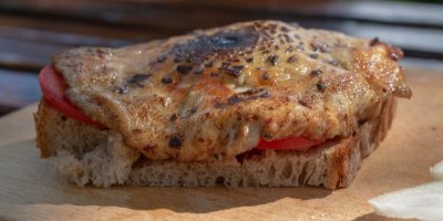 Opečený bedlový klobouk na krajíci chleba s rajčaty