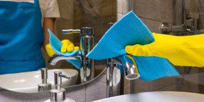 Člověk čistí umyvadlo hadrem