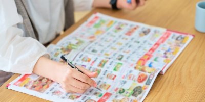 Žena s propiskou sedí u letáku s akčním zbožím