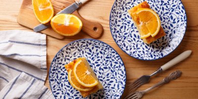 Kousky pomerančového koláče na modrobílých talířích