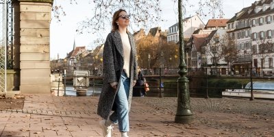 Žena v kabátu jde po ulici