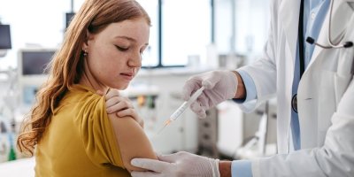 Dívka dostává očkování injekcí