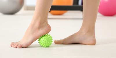 Žena cvičí s masážním míčkem s bodlinkami