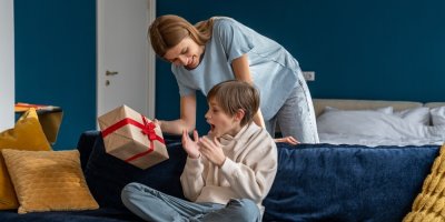 Matka dává svému synovi zabalený dárek