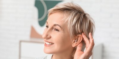 Starší žena má v uchu naslouchátko