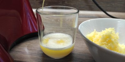 Sklenice s bramborovou šťávou vedle misky se strouhanými brambory