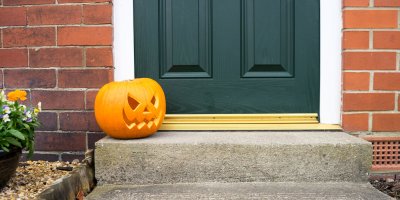 Vyřezaná dýně venku před vstupními dveřmi