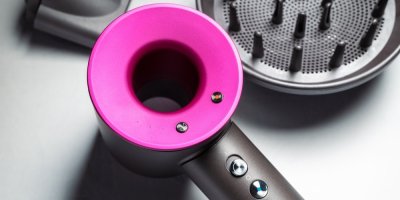 Černo-růžový fén značky Dyson s typickou dutou konstrukcí