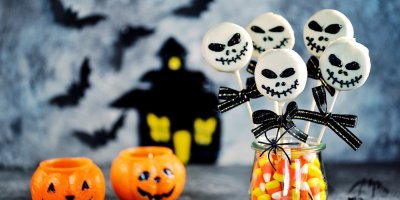 Kulaté sušenky na špejlích namočené v bílé čokoládě a ozdobené obličeji z polevy