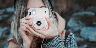 Žena pořizuje snímek instantním fotoaparátem