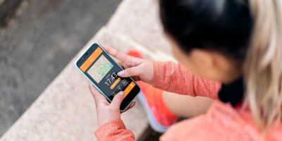 Žena se dívá do sportovní aplikace v chytrém telefonu.