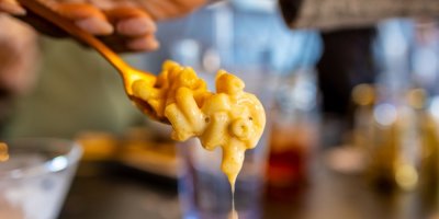 Ruka nabírá lžící krémově sýrové těstoviny