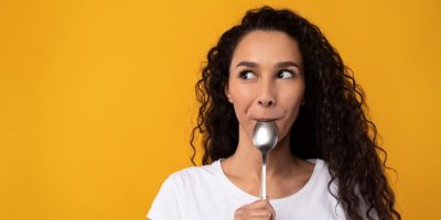 Žena oblizuje lžíci.