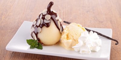 Hruška politá čokoládou, kopeček zmrzliny, šlehačka a vanilkový lusk