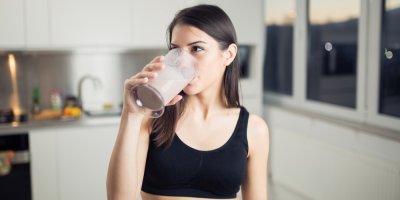 Mladá žena pije mléčný nápoj.