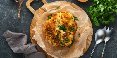 Pečený květák, vedle ubrousek a příbory