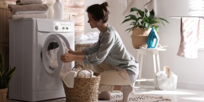 Žena vkládá prádlo do pračky