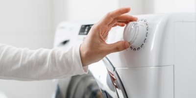 Člověk nastavuje program praní na pračce