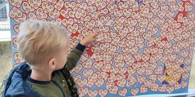 Dítě lepí samolepku srdce dětem