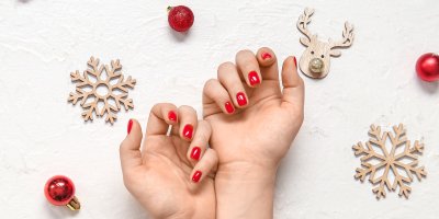 Ruce s červenými nehty, okolo vánoční dekorace