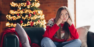 Dívka s otráveným výrazem, v pozadí vánoční stromeček