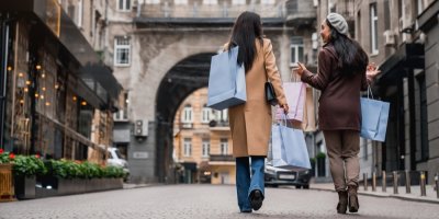 Dvě ženy jdou po ulici s nákupními taškami v rukou