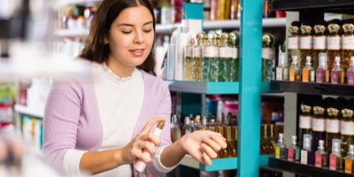 Žena si v obchodě stříká parfém na zápěstí.