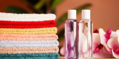 Poskládané ručníky, dva parfémy