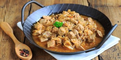 Tradiční segedínský guláš na míse a se lžící plnou koření