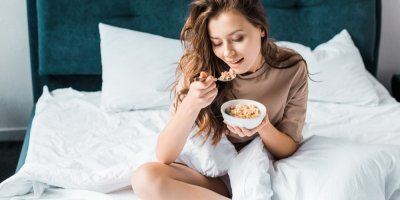 Žena jí v posteli ovesnou kaši