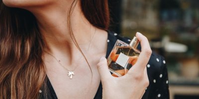 Žena si aplikuje parfém na krk