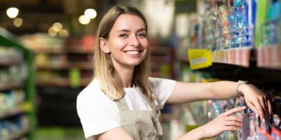 Žena se usmívá a rovná zboží v regále