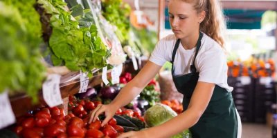 Dívka srovnává v obchodě zeleninu