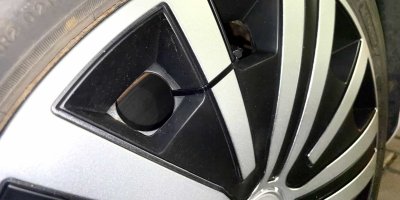 Detail poklice připevněné stahovacím páskem k ráfku