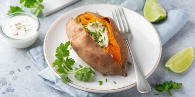 Pečené batáty  rozříznuté napůl, uvnitř je jogurtový dip