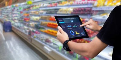 Pracovník supermarketu ovládá tablet s managementovým systémem na obrazovce