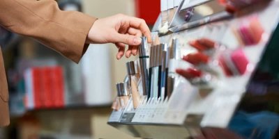 Ruka si bere kosmetický produkt z regálu