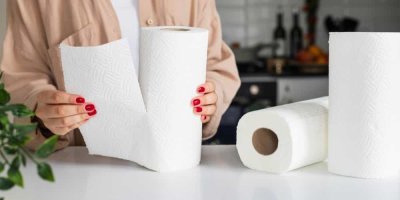 Žena v kuchyni trhá kus papírové utěrky